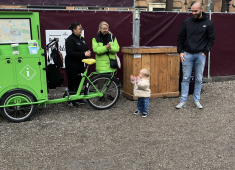 Een kind staat voor een groene fiets met volwassenen in Den Haag.