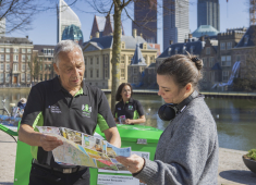 Twee toeristen bekijken een kaart bij de Hofvijver.