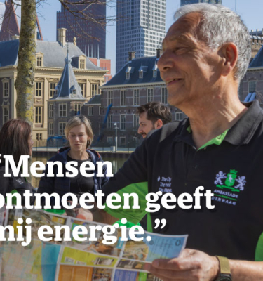 Een man en een vrouw praten buiten bij de Hofvijver in Den Haag.