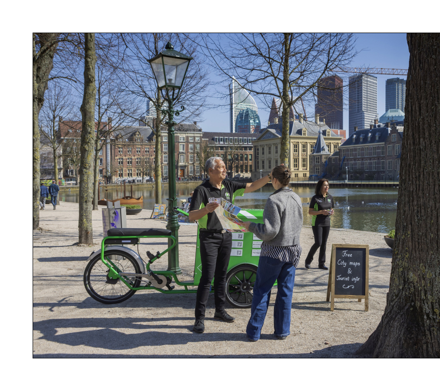 Een man geeft een stadskaart aan een vrouw bij de Hofvijver.