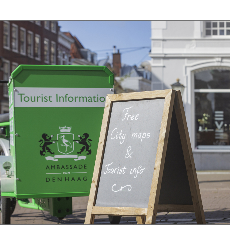 Green bike with tourist information and a sign for free city maps