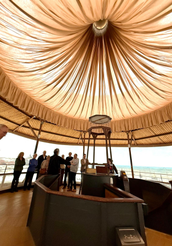 Groep mensen tijdens een presentatie onder een stijlvolle, gouden koepel.