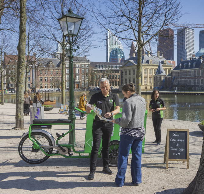 Two people receiving tourist information at the Hofvijver.
